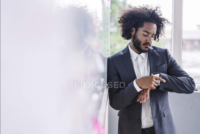 Молодой бизнесмен использует умные часы — стоковое фото