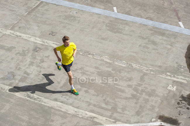 Junger Mann joggt auf Betonboden — Stockfoto