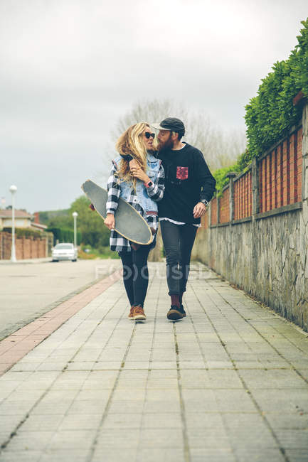 Пара закоханих у скейтборд, що йде на тротуарі — стокове фото