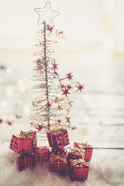 Miniatur-Weihnachtsbaum mit kleinen roten Weihnachtsgeschenkboxen — Stockfoto