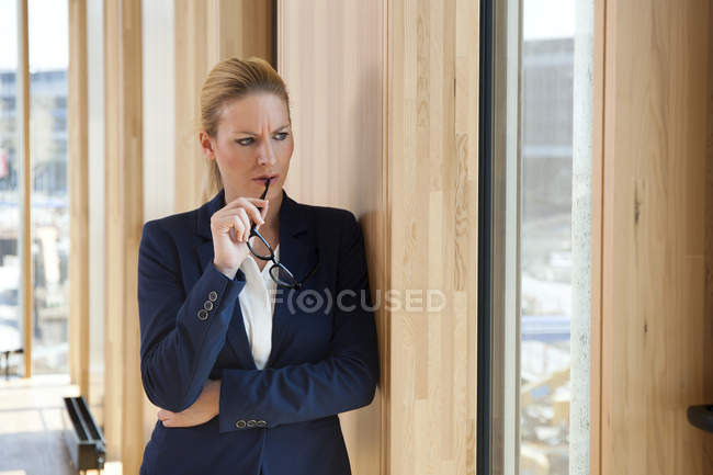 Femme d'affaires appuyé contre le mur de pensée — Photo de stock