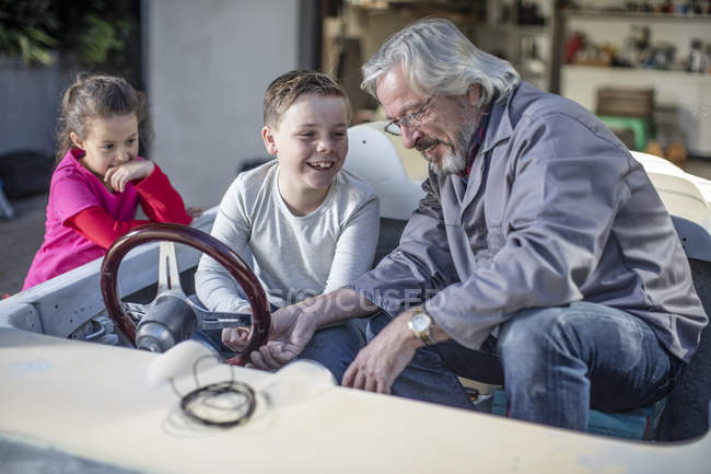Sorrindo homem sênior com menino e menina sentados no conversível — Fotografia de Stock