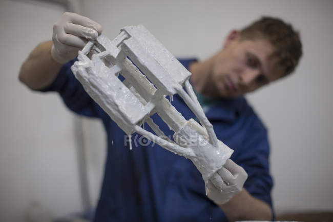 Young caucasian male worker holding cast — Stock Photo
