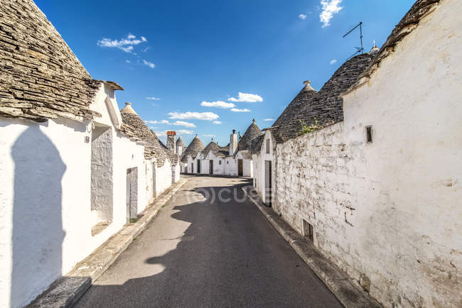 Italia, Apulia, Alberobello, Trulli, cabañas de piedra seca con techos cónicos - foto de stock