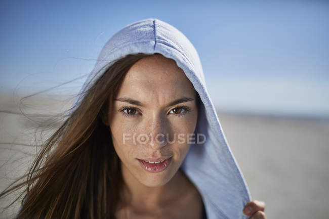Schöne kaukasische Frau mit Kapuze schaut in die Kamera — Stockfoto
