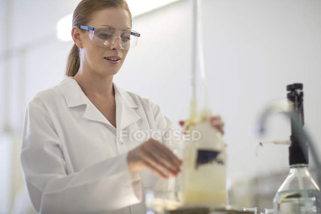 Joven mujer caucásica trabajando en laboratorio - foto de stock