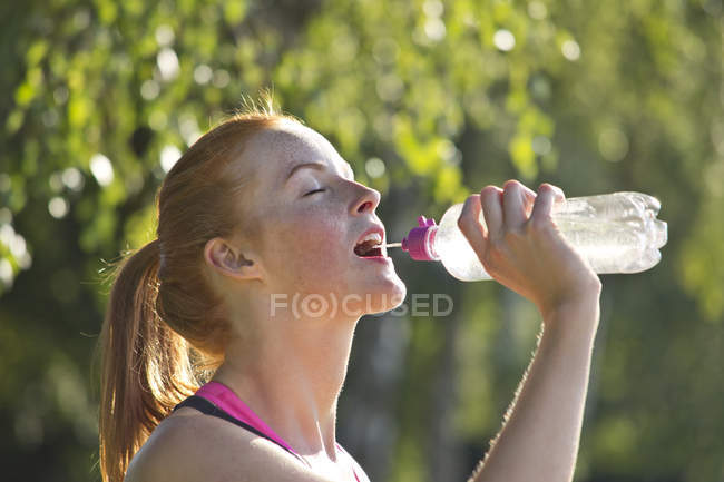 Atleta beber agua de la botella - foto de stock