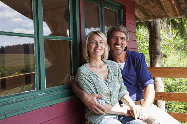 Feliz pareja madura en el porche de la casa de verano - foto de stock