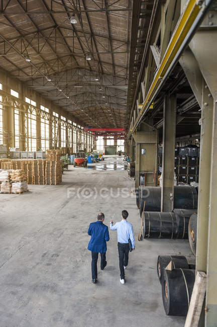 Two men walking through factory hall, elevated view — Stock Photo