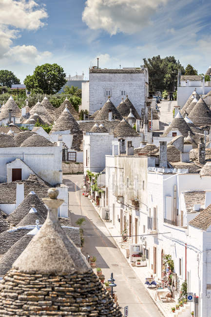 Italia, Apulia, Alberobello, Trulli, cabañas de piedra seca con techos cónicos - foto de stock