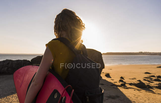 Adolescente carregando prancha de surf na praia — Fotografia de Stock