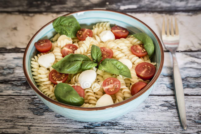 Nudelsalat mit Tomaten, Mozzarella und Basilikum — Stockfoto