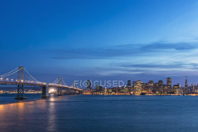 USA, California, San Francisco skyline and Oakland Bay Bridge in the evening — Stock Photo