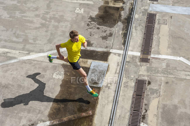Jovem jogging homem no chão de concreto — Fotografia de Stock