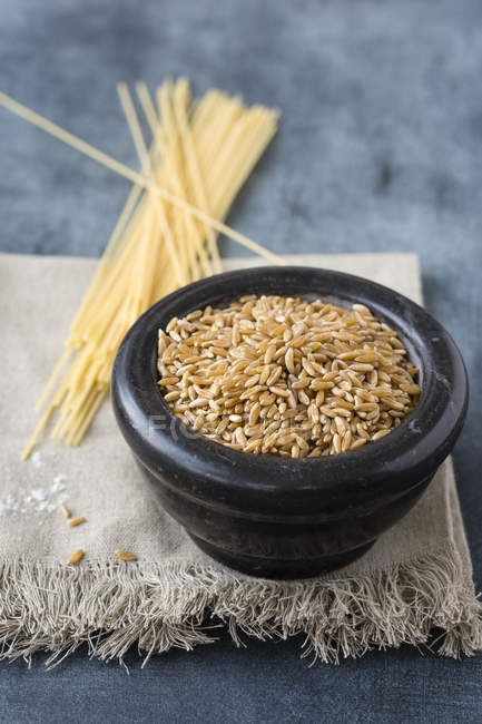 Bowl of polish wheat and spaghetti made of polish wheat on cloth — Stock Photo