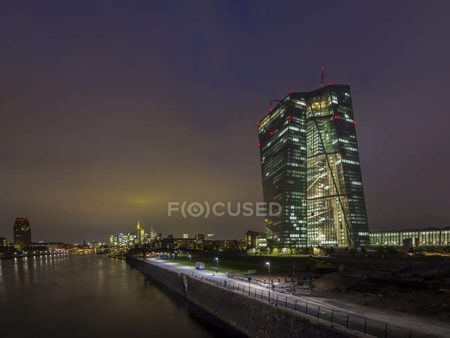 Alemania, Hesse, Frankfurt, vista al iluminado Banco Central Europeo al atardecer - foto de stock