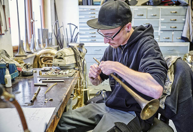 Fabricant d'instruments faisant trompette en atelier — Photo de stock