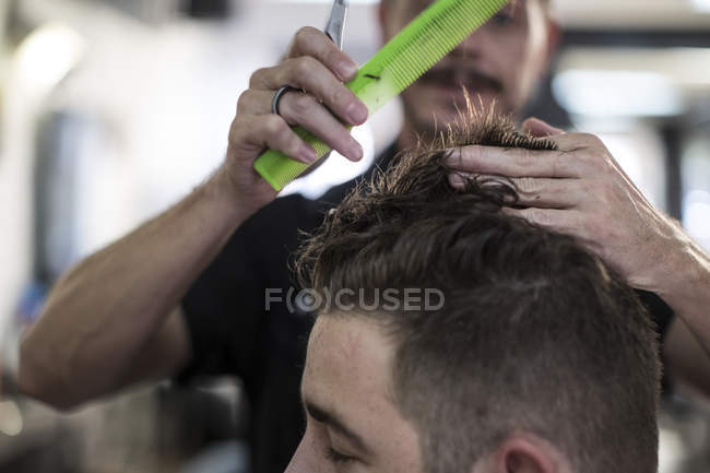 Pettinatura e taglio capelli da barbiere di un cliente dal barbiere — Foto stock