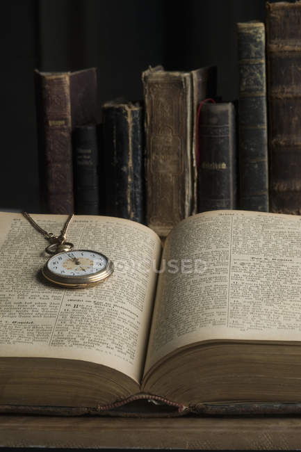 Livre ouvert avec vieille montre de poche — Photo de stock