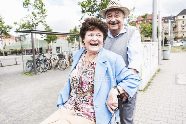 Heureux couple aîné avec marcheur à roues — Photo de stock