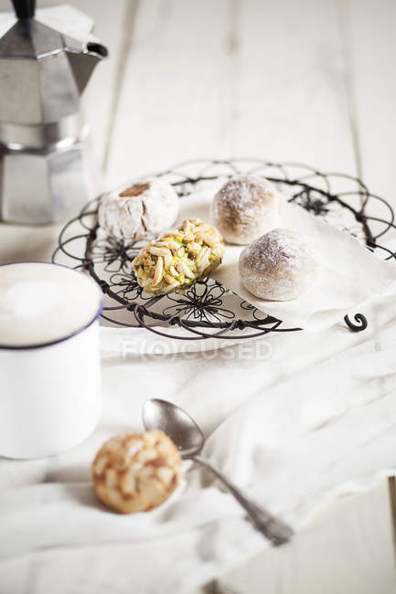Tazza di cappuccino, biscotti di mandorle italiane e barattolo di caffè espresso — Foto stock