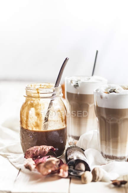 Bicchieri di zucca spezia latte macchiato e spezie su stoffa — Foto stock