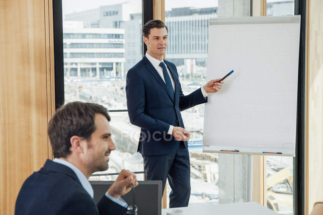 Businessman leading a presentation at flip chart — Stock Photo