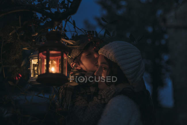 Italy, Grosseto, siblings with lighted Christmas lantern by night — Stock Photo