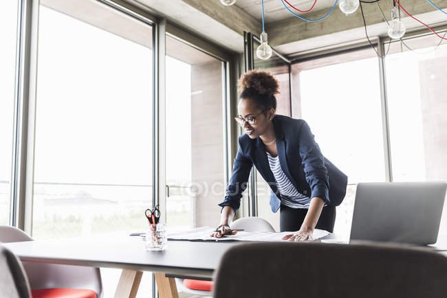 Geschäftsfrau steht in modernem Büro neben Schreibtisch — Stockfoto