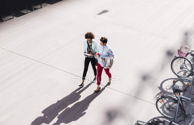 Two businesswomen walking and talking outdoor — Stock Photo