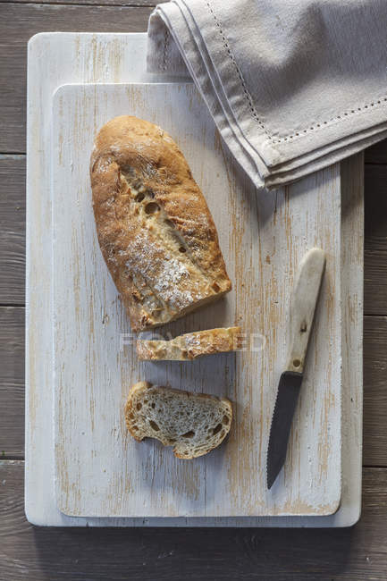 Baguette e coltello su tavola da cucina — Foto stock