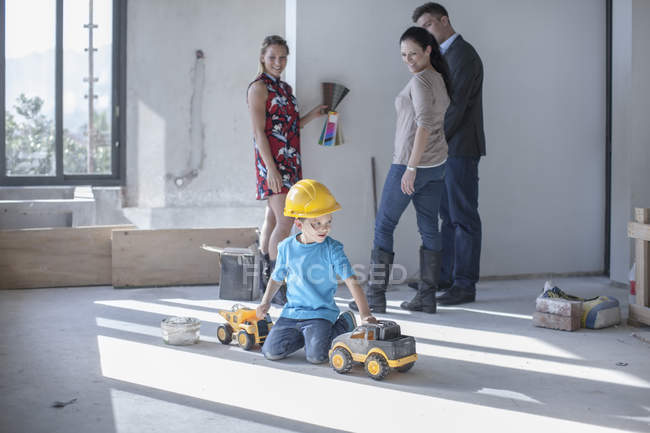Niño con sombrero duro jugando en el sitio de construcción - foto de stock