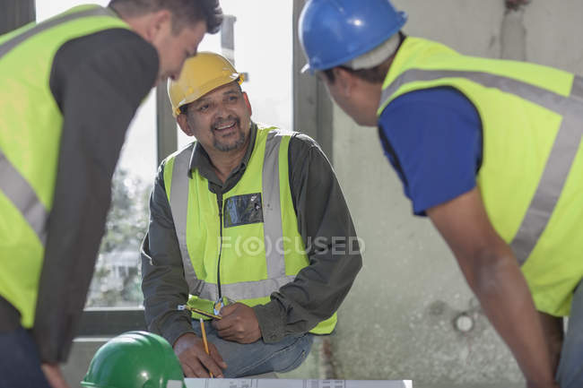 Architect and construction workers on construction site — Stock Photo