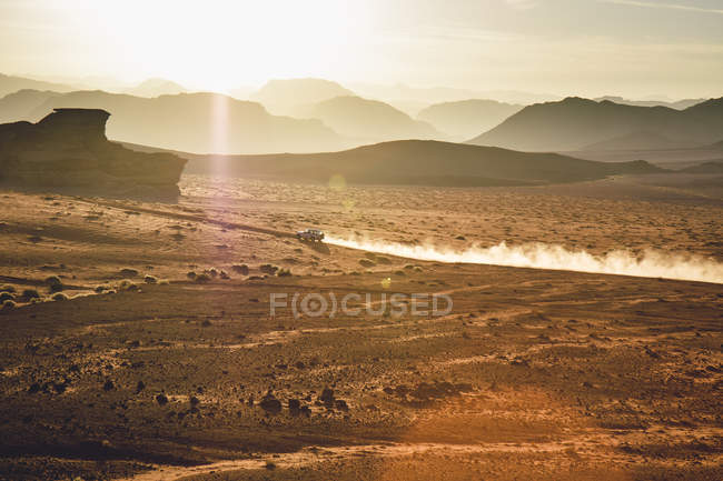 Jordania, polvo de arena de un vehículo de 4 ruedas en el desierto de Wadi Rum durante el día - foto de stock