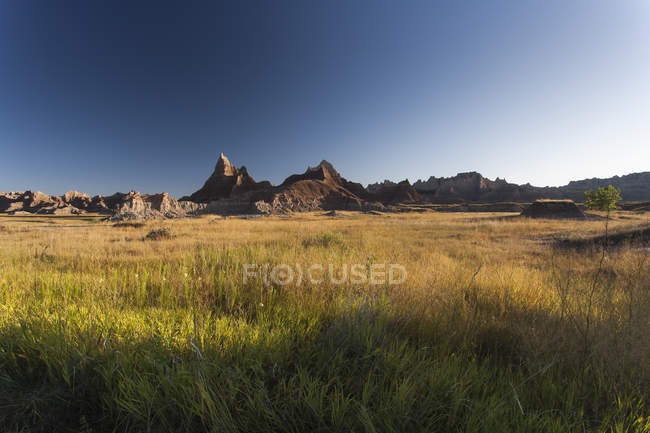 США, Южная Дакота, Национальный парк Бэдлендс, Пейзаж с холмом на заднем плане — стоковое фото