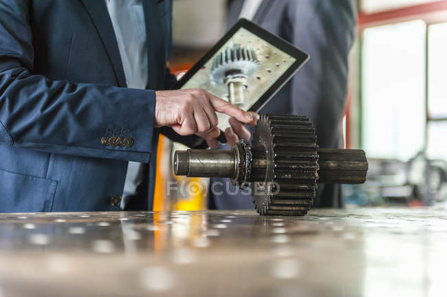 Ingenieure mit digitalem Tablet und Getriebe — Stockfoto