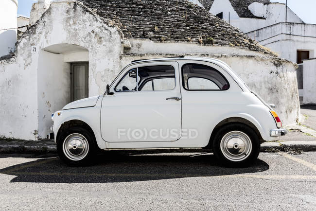 Italia, Apulia, Alberobello, viejo Fiat 500 estacionado frente a Trullo - foto de stock