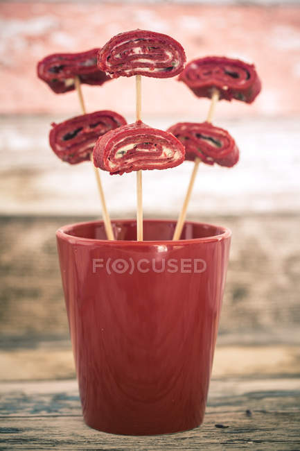 Crêpes de betteraves roulées sur des brochettes dans une tasse — Photo de stock