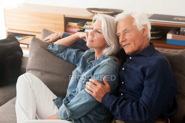 Ritratto di coppia anziana amorevole seduta fianco a fianco sul divano — Foto stock