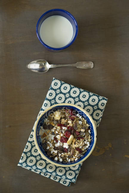 Fruit muesli with puffed buckwheat in bowl on brown wooden surface — Stock Photo