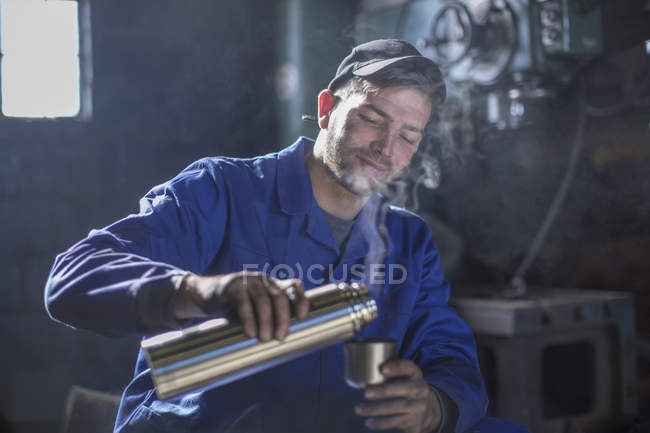 Mecánico en taller con pausa para el café - foto de stock