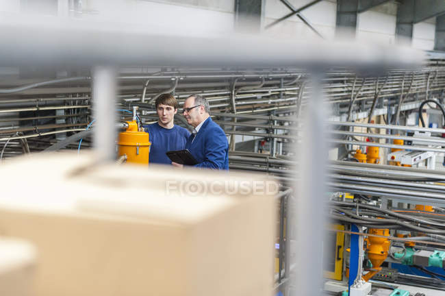 Manager and worker having work meeting in plastics factory — Stock Photo