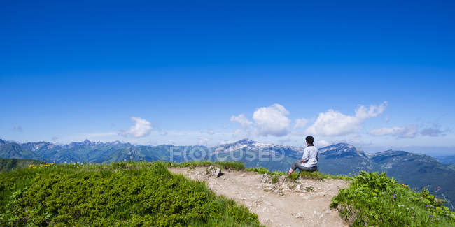 Alemania, Baviera, Alpes Allgaeu, Fellhorn, excursionista sentada en el mirador, vista a Soellereck - foto de stock