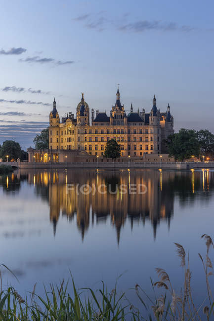 Germany, Mecklenburg-Vorpommern, Schwerin, Schwerin Castle at dawn over water — Stock Photo
