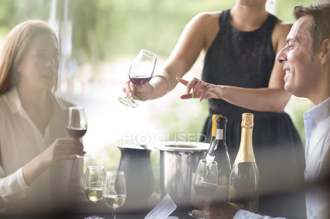 Cameriera in ristorante che presenta vino rosso — Foto stock