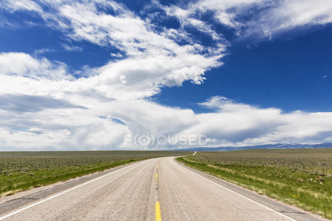 USA, Wyoming, Empty Highway 26 e cielo nuvoloso — Foto stock