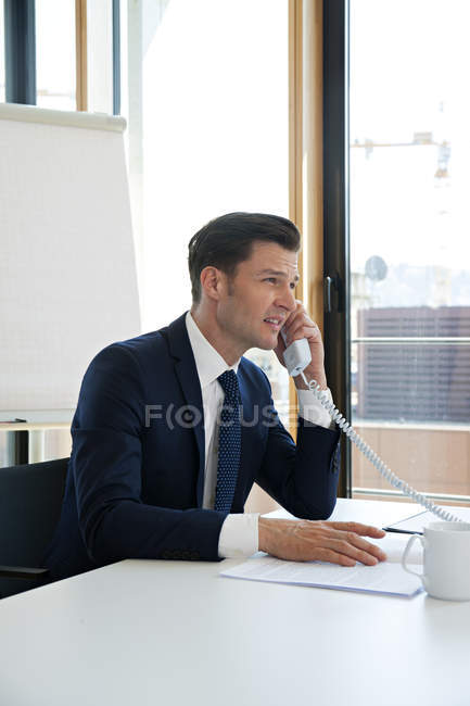 Homme d'affaires au bureau au téléphone — Photo de stock
