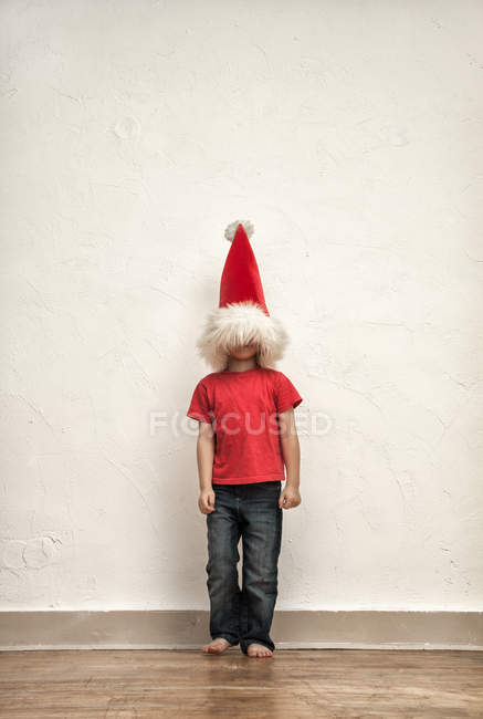 Petit garçon caché visage sous bonnet de Noël surdimensionné — Photo de stock