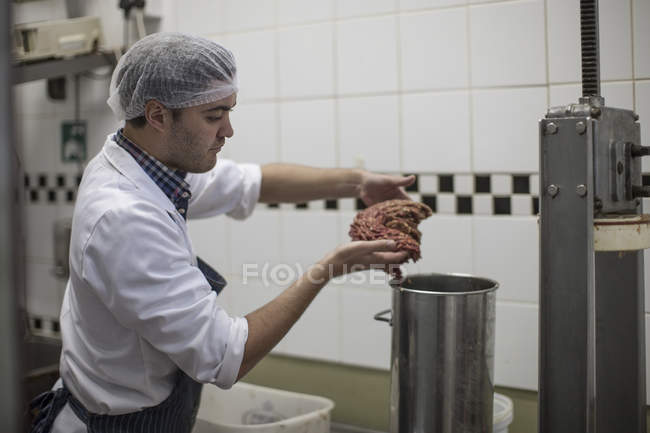 Butcher processing minced meat in butchery — Stock Photo