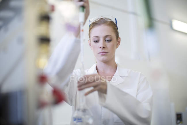 Jeune femme caucasienne travaillant en laboratoire — Photo de stock